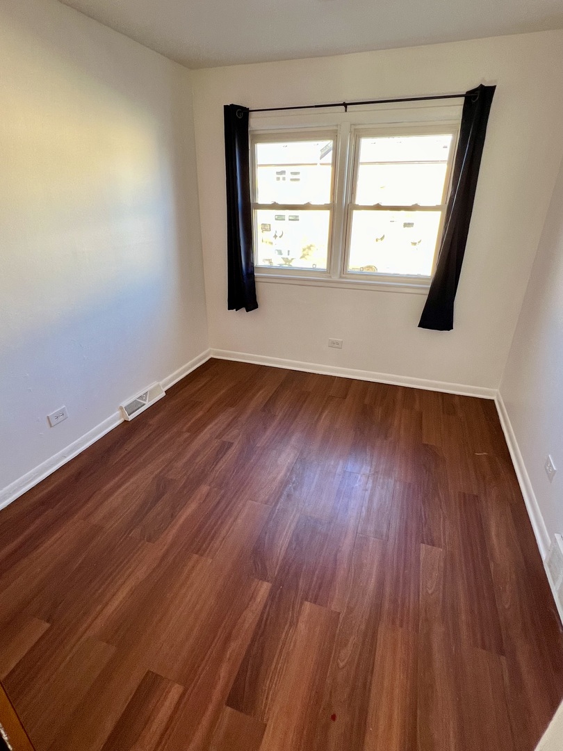 9559 Sumac Road, Unit F Des Plaines, IL 60016 - Photo 15 of 24 an empty room with wooden floor and windows