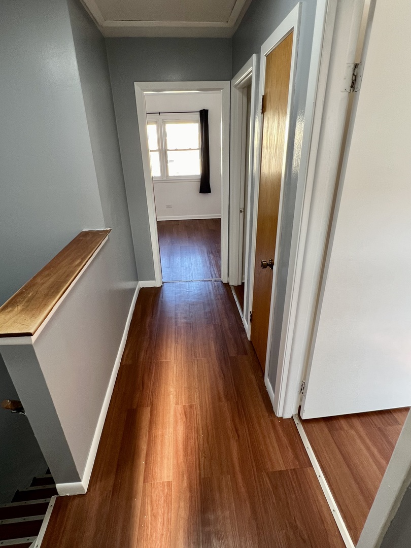 9559 Sumac Road, Unit F Des Plaines, IL 60016 - Photo 16 of 24 a view of a hallway with wooden floor and stairs