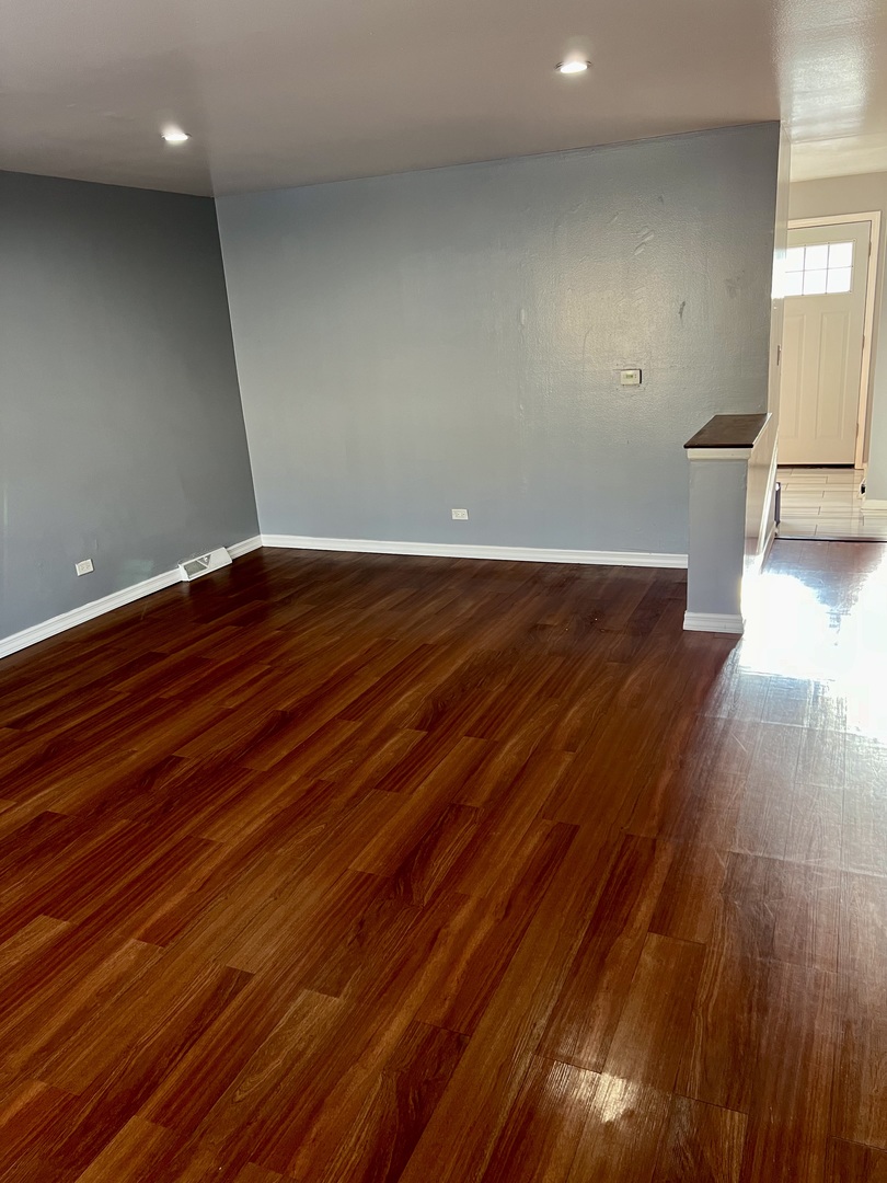 9559 Sumac Road, Unit F Des Plaines, IL 60016 - Photo 3 of 24 a view of room with wooden floor and fan