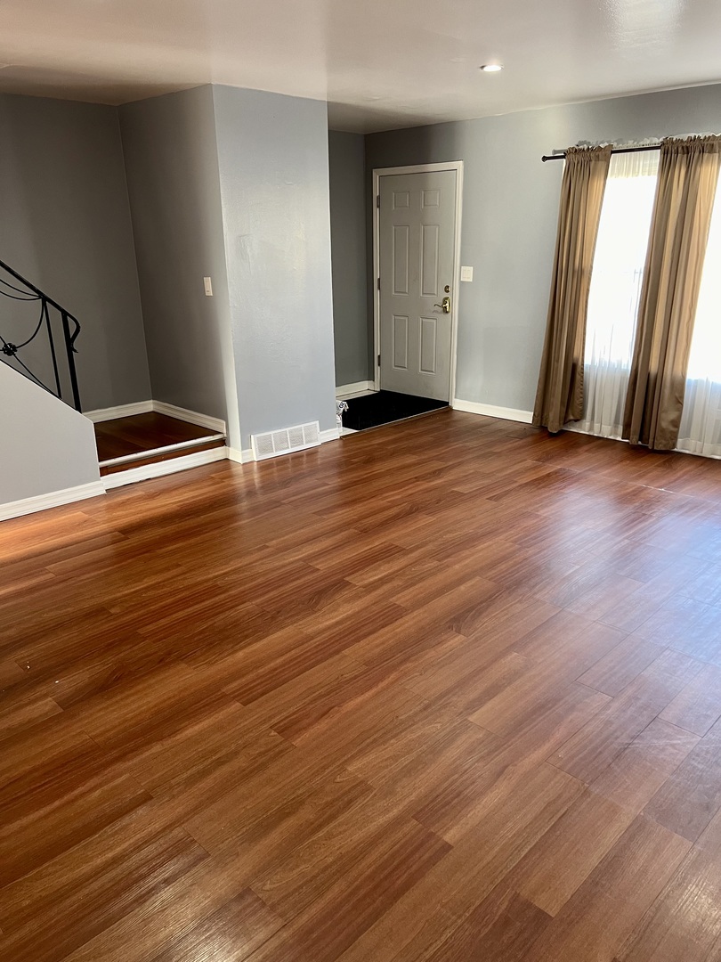 9559 Sumac Road, Unit F Des Plaines, IL 60016 - Photo 6 of 24 an empty room with wooden floor and window