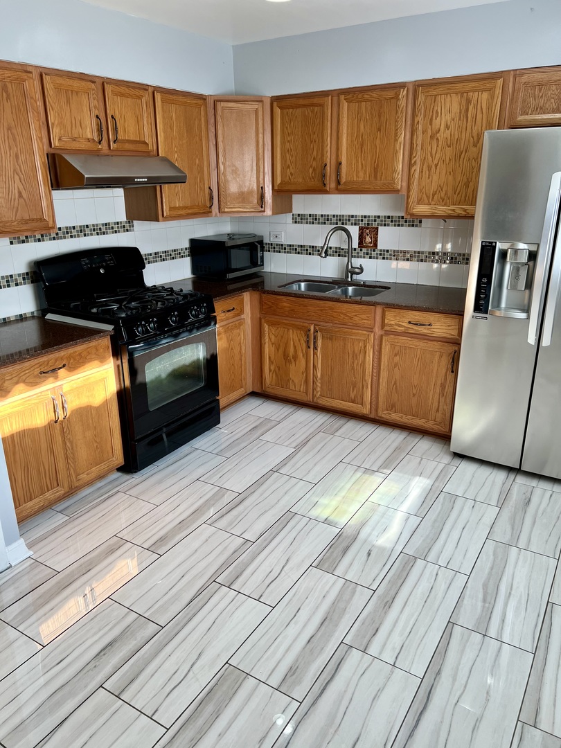 9559 Sumac Road, Unit F Des Plaines, IL 60016 - Photo 9 of 24 a kitchen with stainless steel appliances granite countertop a stove a sink and a refrigerator
