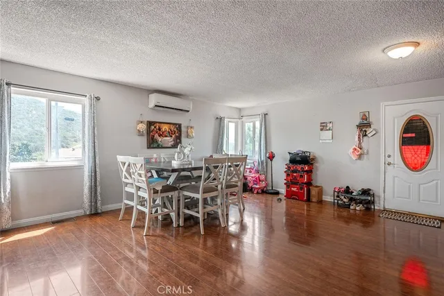 a kitchen with stainless steel appliances granite countertop a stove top oven a sink dishwasher and a dining table with wooden floor