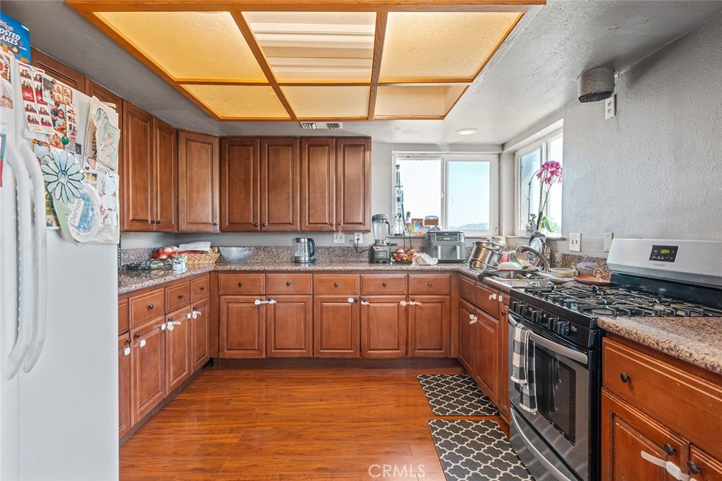1996 Rainbow Glen Fallbrook, CA 92028 - Photo 26 of 55 a large kitchen with stainless steel appliances granite countertop a sink stove and cabinets