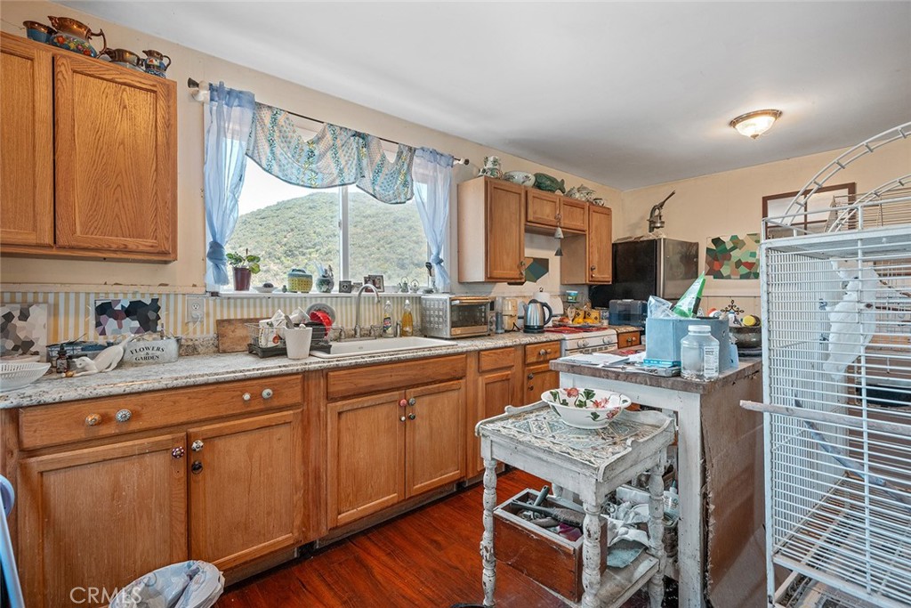 1996 Rainbow Glen Fallbrook, CA 92028 - Photo 39 of 55 a open kitchen with stainless steel appliances granite countertop a stove top oven a sink dishwasher and cabinets with wooden floor