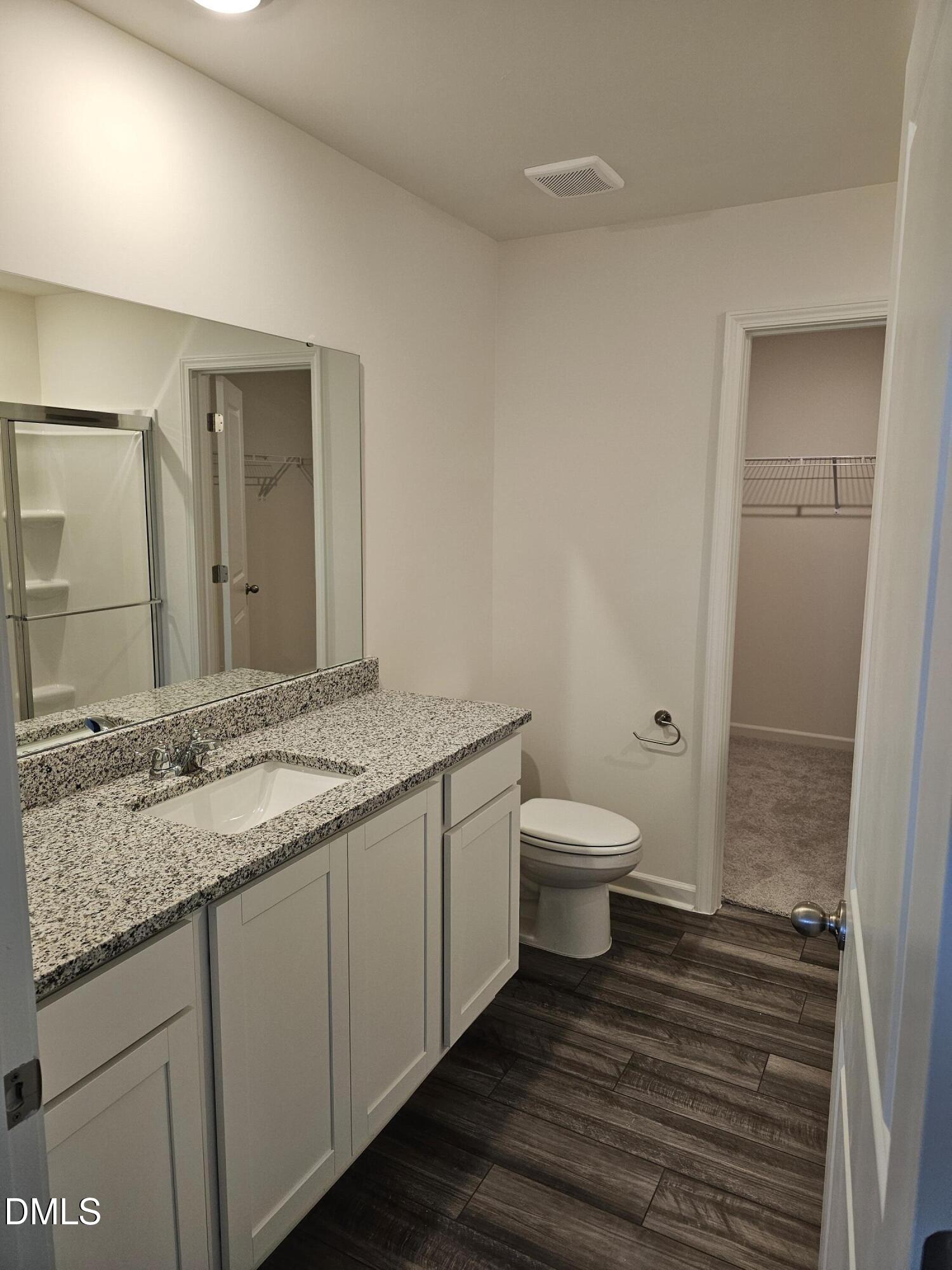 1253 Solace Way Rolesville, NC 27571 - Photo 25 of 31 a bathroom with a granite countertop toilet a sink and a mirror