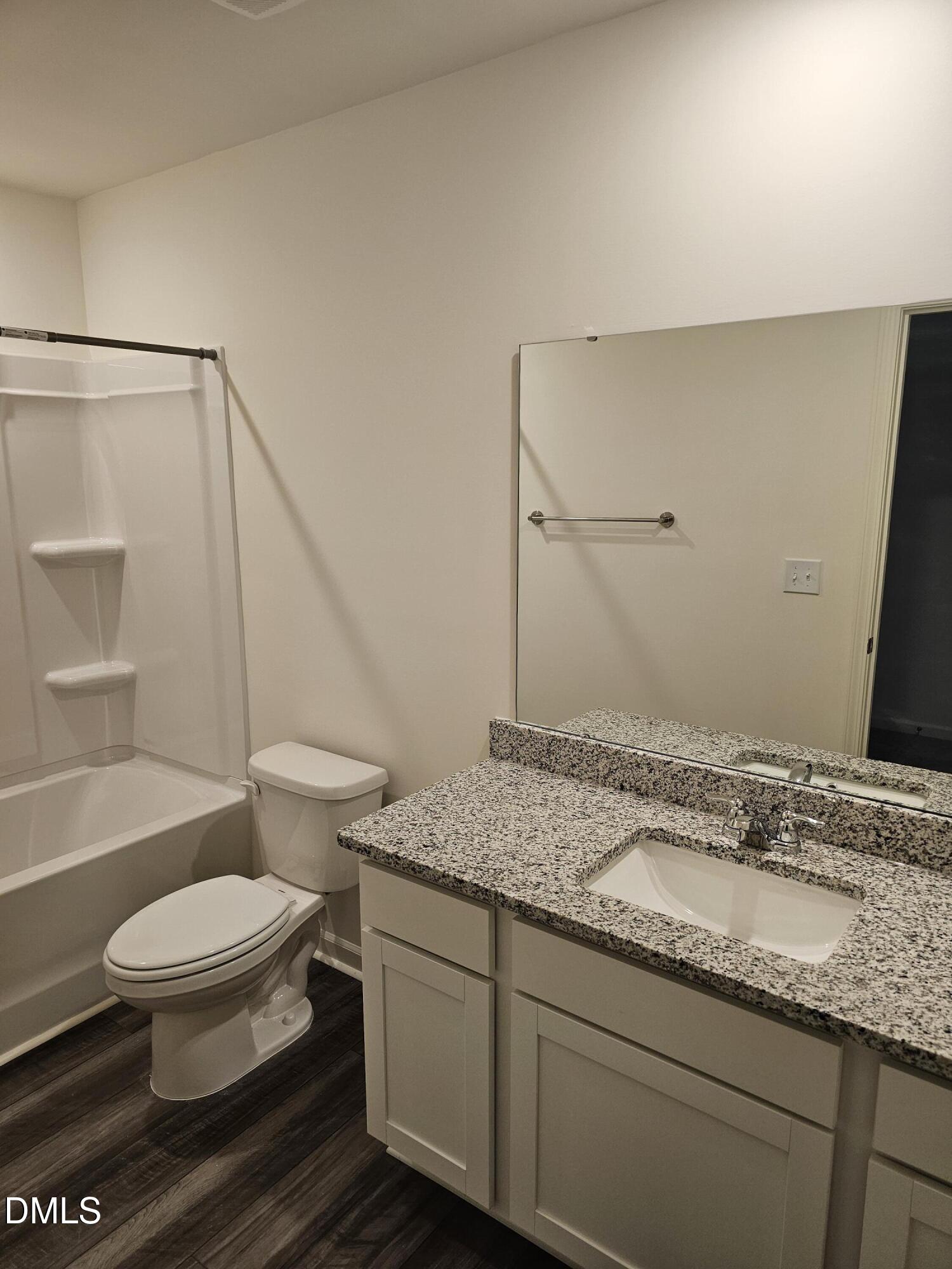 1253 Solace Way Rolesville, NC 27571 - Photo 27 of 31 a bathroom with a granite countertop sink toilet a mirror and shower