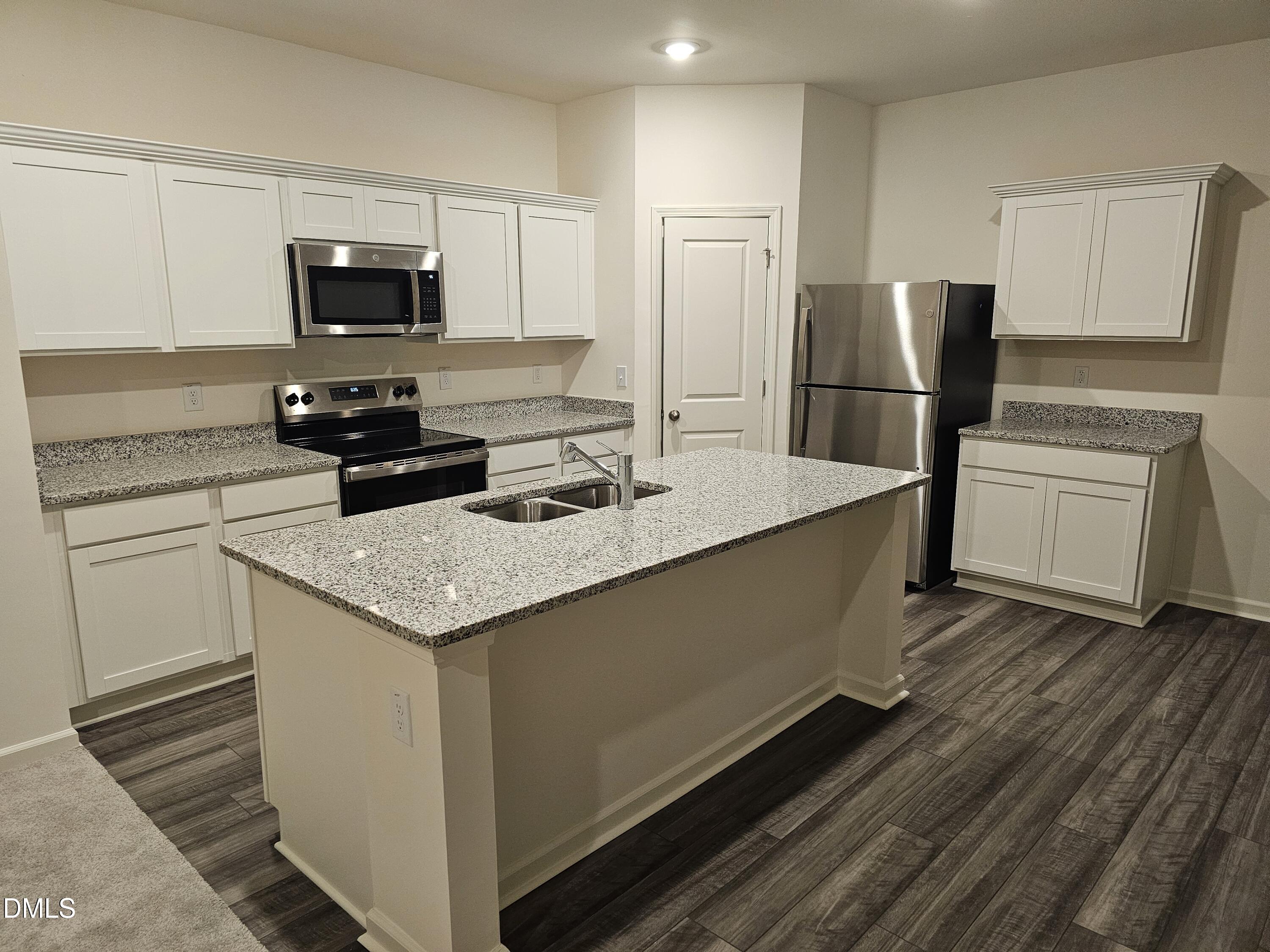 1253 Solace Way Rolesville, NC 27571 - Photo 5 of 31 a kitchen with a sink a stove a refrigerator and white cabinets