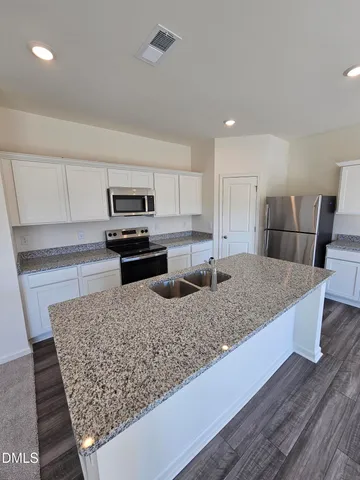 a kitchen with a refrigerator and a stove top oven