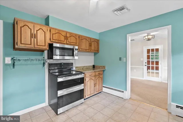 a kitchen with stainless steel appliances granite countertop a refrigerator and a stove top oven