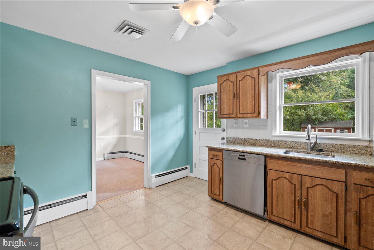 919 Ednor Road Silver Spring, MD 20905 - Photo 13 of 29 a spacious bathroom with a granite countertop sink a mirror and a bathtub with shower