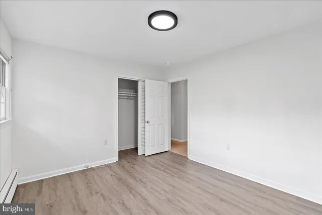 a view of room with wooden floor and ceiling fan