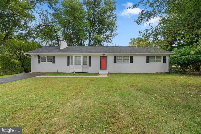 a front view of house with yard and trees around
