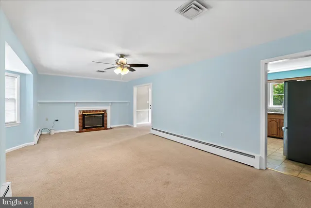 an empty room with windows and ceiling fan