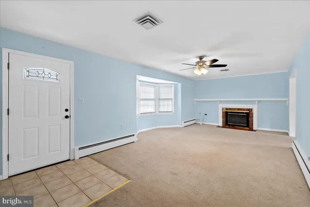 a view of an empty room with a fireplace and a window