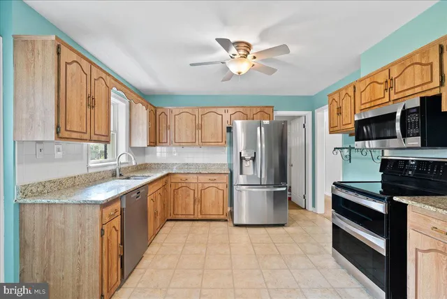 a kitchen with stainless steel appliances granite countertop a refrigerator and a sink