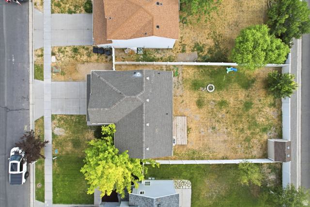 5485 Heather Way Tooele, UT 84074 - Photo 36 of 41 Expansive property featuring a grey asphalt shingle roof, concrete driveway, front yard with mature trees, a privacy fence, and a backyard with a storage shed