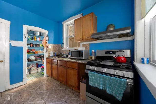 a kitchen with stainless steel appliances granite countertop a stove and cabinets