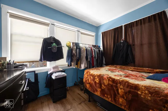 a bedroom with a bed and two windows