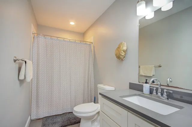 a bathroom with a granite countertop sink toilet and shower