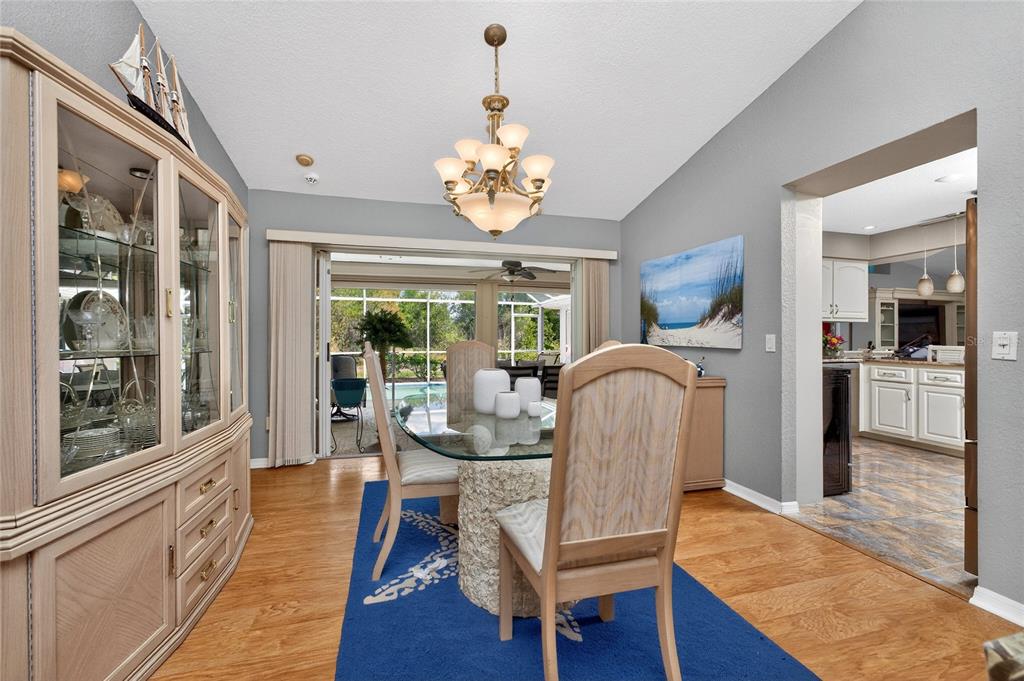 100 Angol Street Punta Gorda, FL 33983 - Photo 12 of 56 a dining room with wooden floor a chandelier a wooden table and chairs