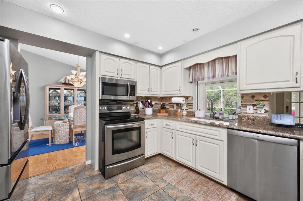 100 Angol Street Punta Gorda, FL 33983 - Photo 18 of 56 a kitchen with stainless steel appliances granite countertop a stove sink and microwave