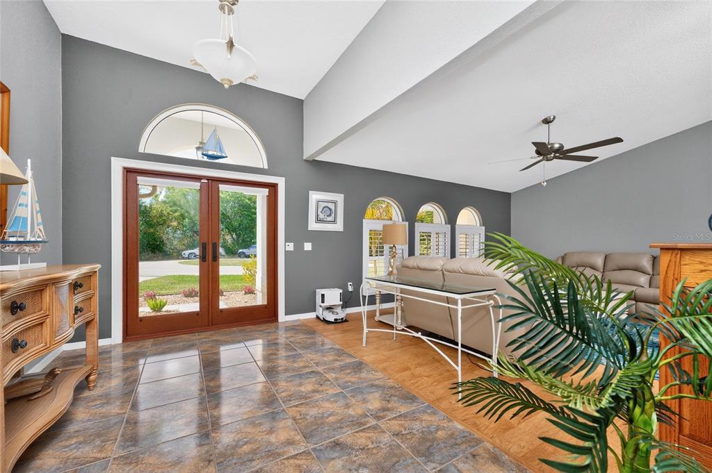 100 Angol Street Punta Gorda, FL 33983 - Photo 7 of 56 a living room with a balcony furniture a chandelier and a large window