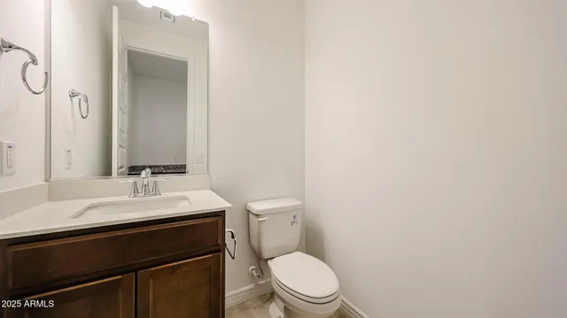 a bathroom with a sink a toilet a mirror and vanity