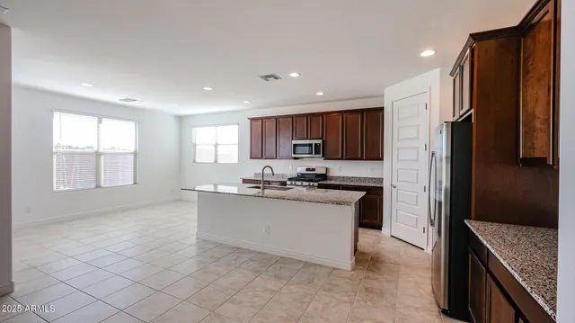 a kitchen with stainless steel appliances granite countertop a stove a sink and a refrigerator