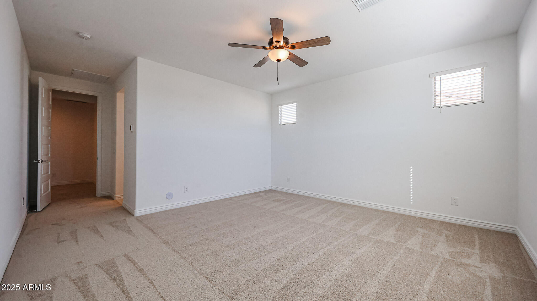 25051 North 171st Avenue Surprise, AZ 85387 - Photo 7 of 19 a view of an empty room with a ceiling fan