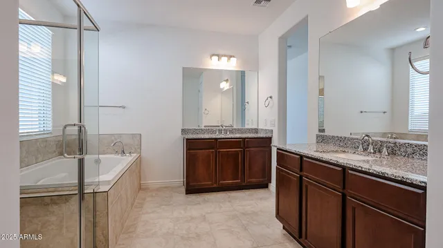 a bathroom with a tub sink and mirror