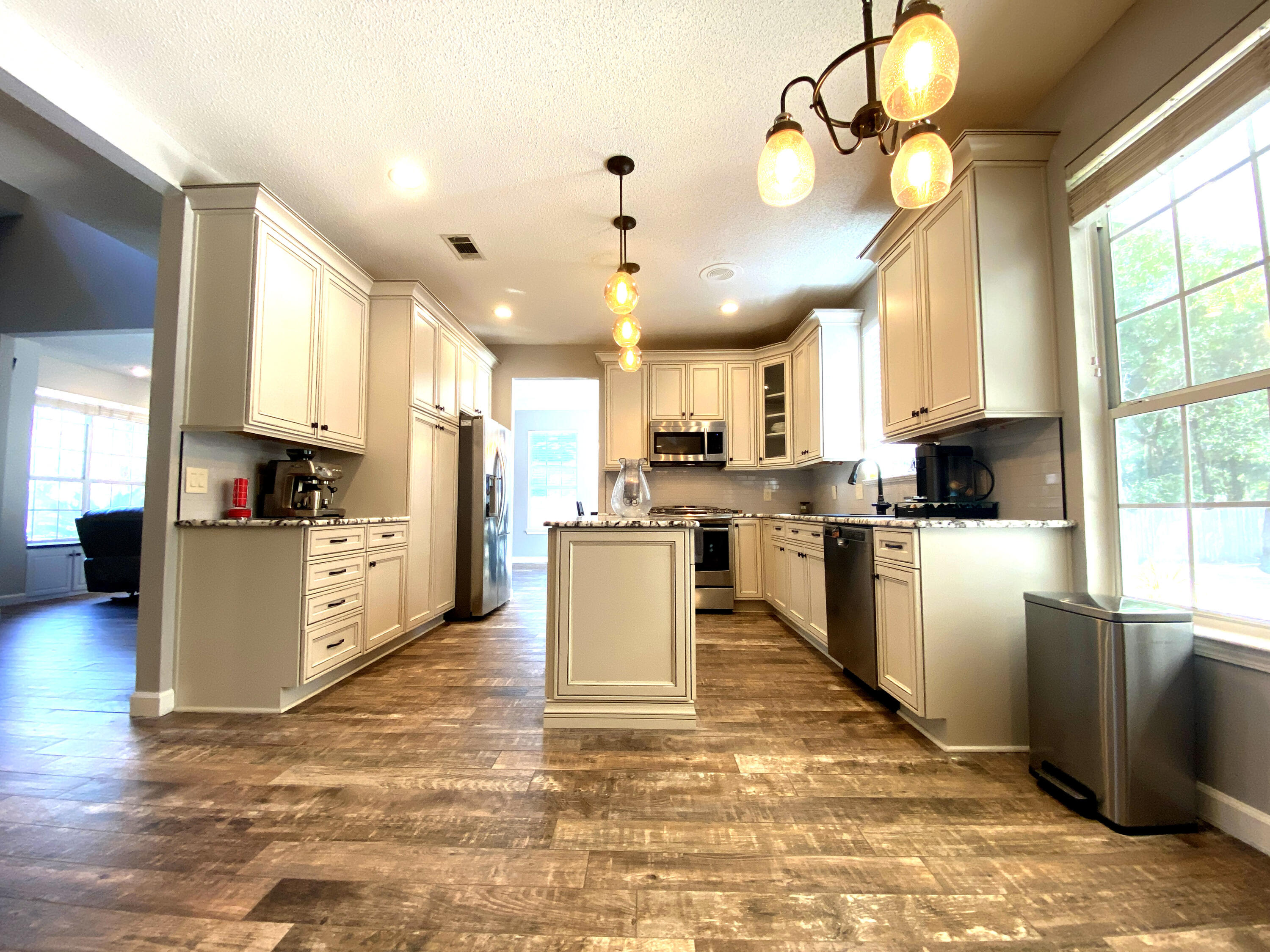 4466 Kingslynn Road Niceville, FL 32578 - Photo 17 of 77 a kitchen with stainless steel appliances kitchen island granite countertop a refrigerator a stove top oven a sink dishwasher and white cabinets with wooden floor