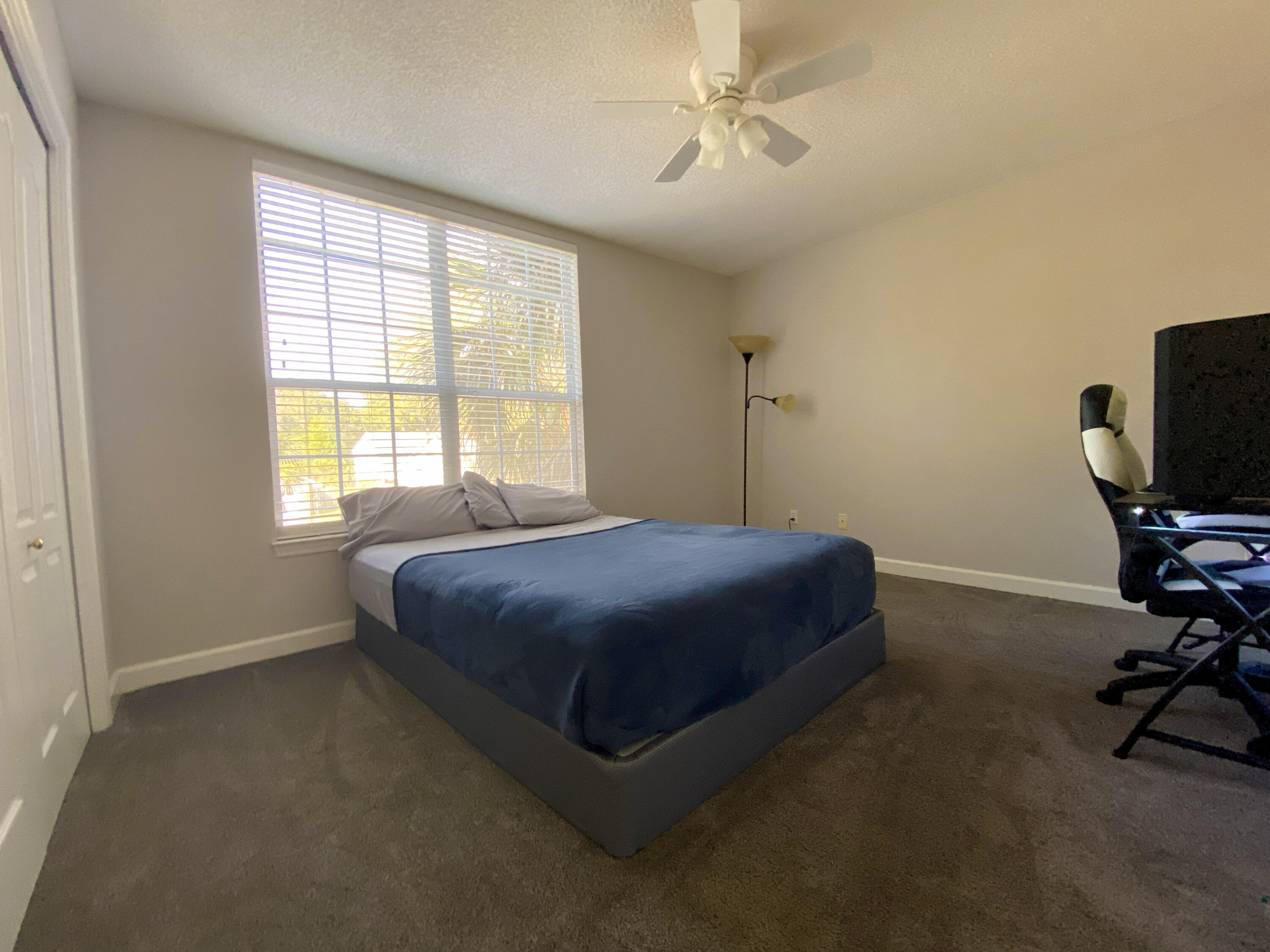 4466 Kingslynn Road Niceville, FL 32578 - Photo 50 of 77 a bedroom with a bed a chandelier and a window
