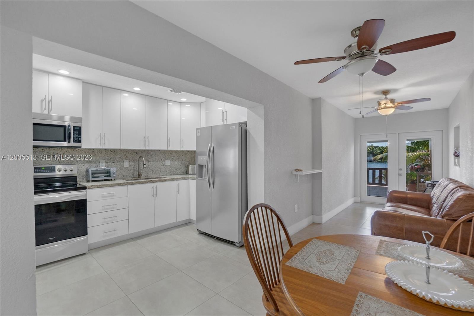 862 West 79th Street Hialeah, FL 33014 - Photo 8 of 34 a kitchen with stainless steel appliances granite countertop a refrigerator a stove a sink a dining table and chairs with wooden floor