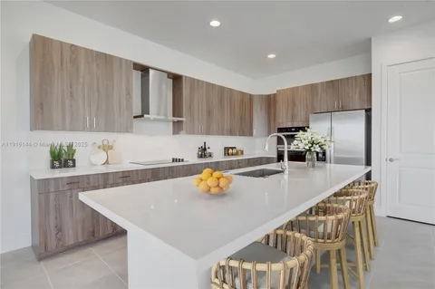 a kitchen with stainless steel appliances granite countertop a sink refrigerator and cabinets
