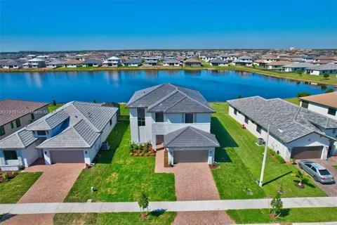 an aerial view of a house with a garden and lake view