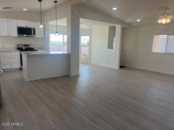 a view of empty room with window and wooden floor
