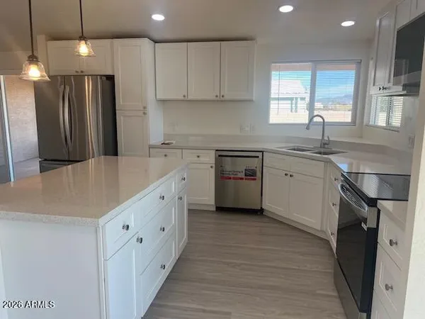 a view of empty room with window and wooden floor