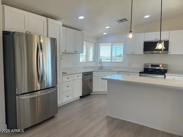 a kitchen with stainless steel appliances a refrigerator sink and microwave