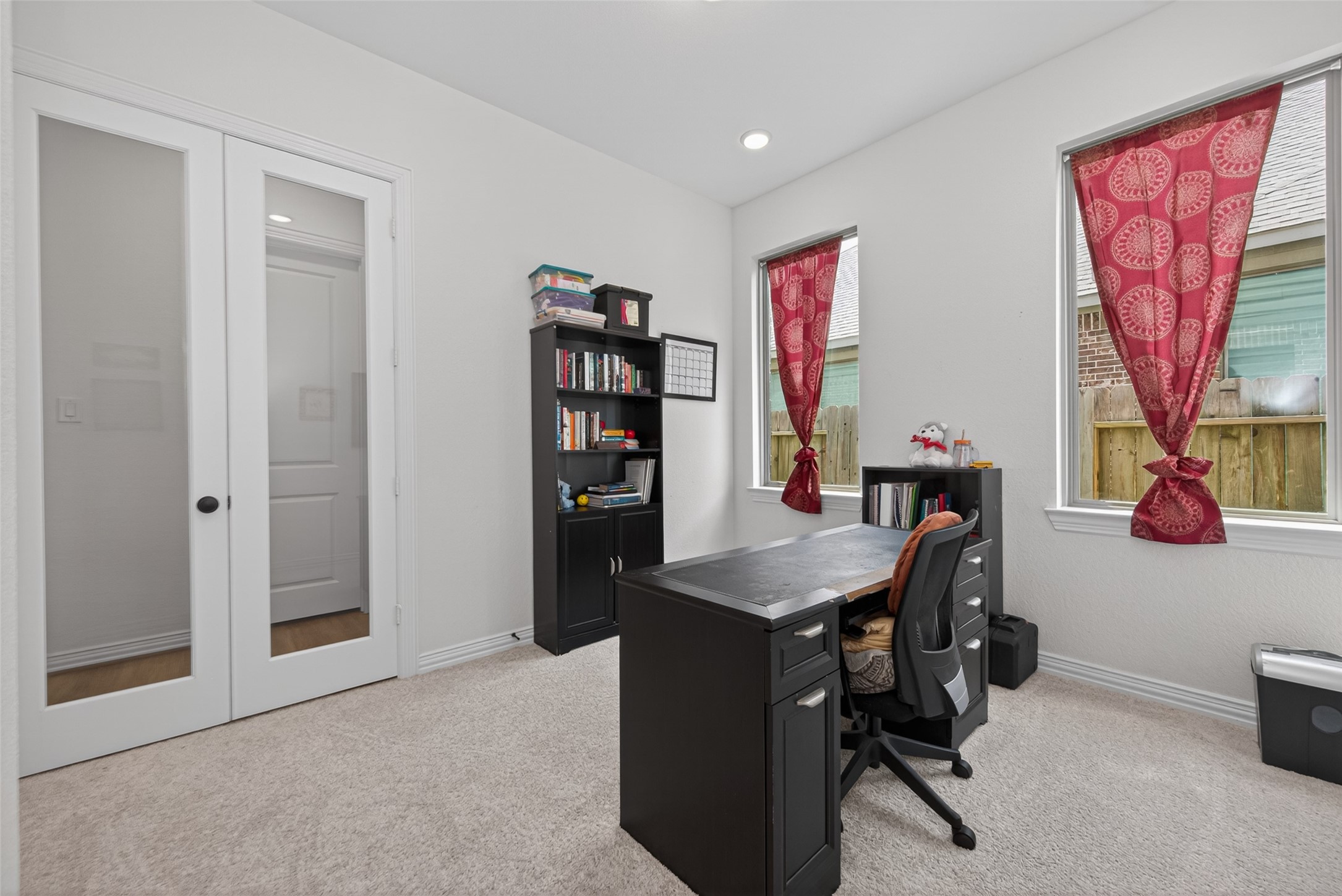 20802 Mirror Point Drive Cypress, TX 77433 - Photo 14 of 37 A well-lit home office, complete with carpeted flooring and elegant glass double doors, provides a seamless and inviting environment conducive to both work and creative endeavors.