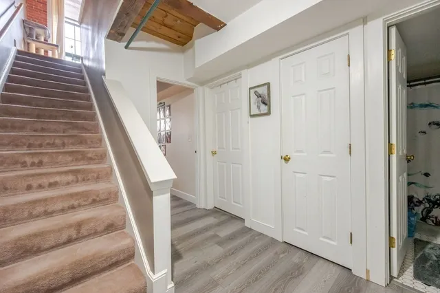 a view of a hallway with wooden floor and staircase