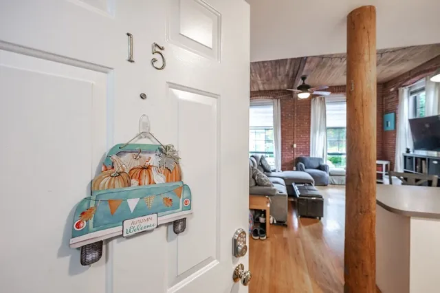 a large kitchen with stainless steel appliances a stove a sink dishwasher and a fireplace with wooden floor