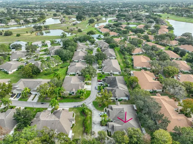 an aerial view of residential houses with outdoor space and trees