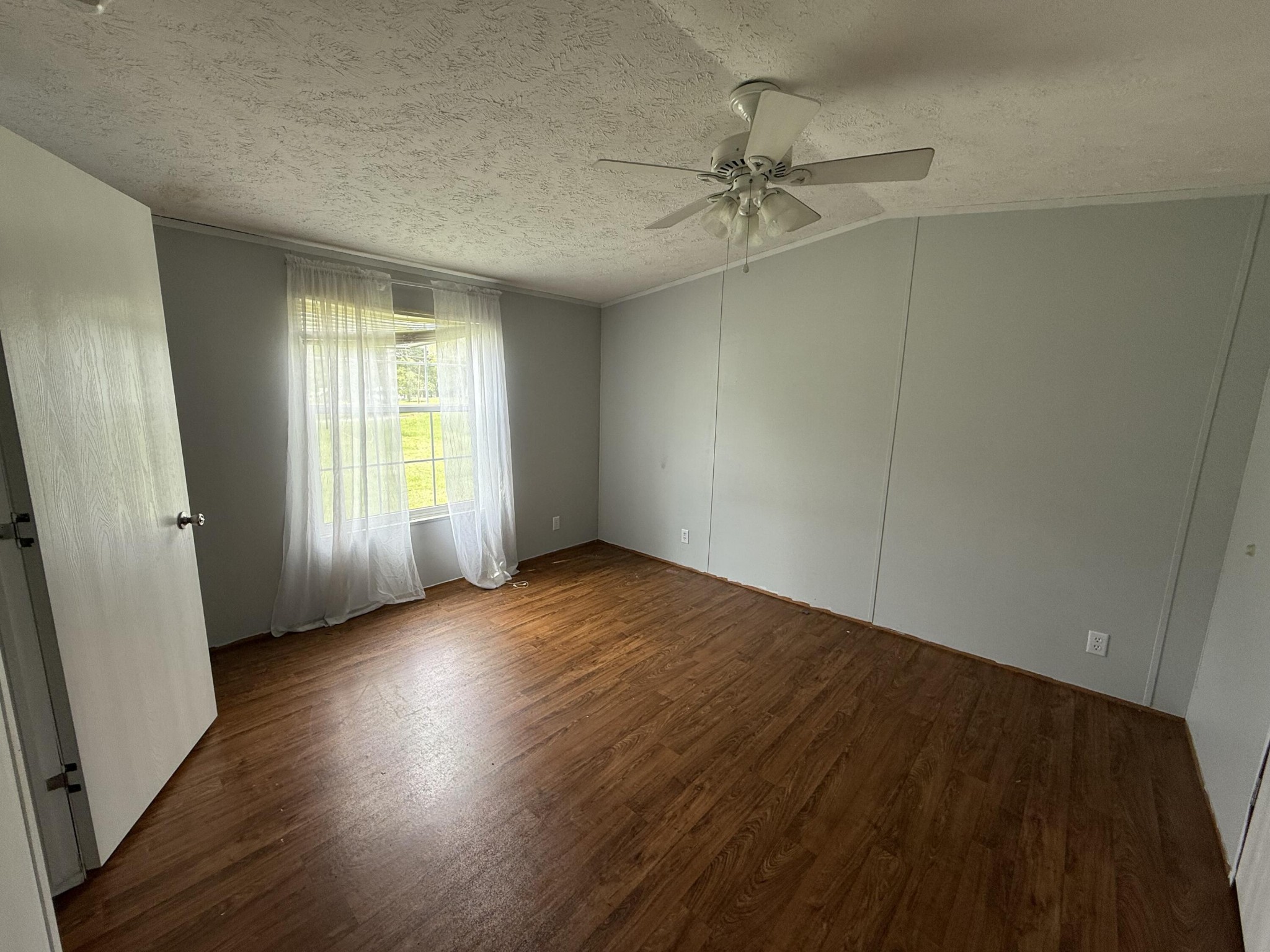 1001 Old Three Notch Road Ringgold, GA 30736 - Photo 9 of 26 an empty room with wooden floor fan and windows