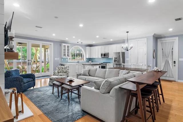 a kitchen with stainless steel appliances granite countertop a stove a sink dishwasher and a refrigerator with wooden floor