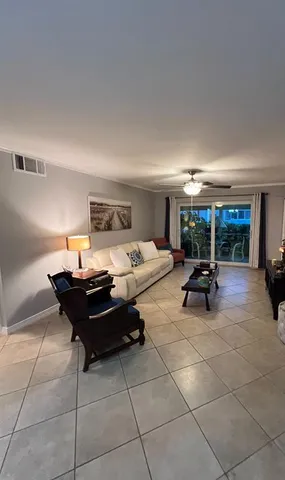 a living room with furniture kitchen view and a flat screen tv