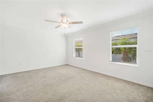 an empty room with a window and a fan