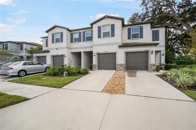a front view of a house with a garden and parking