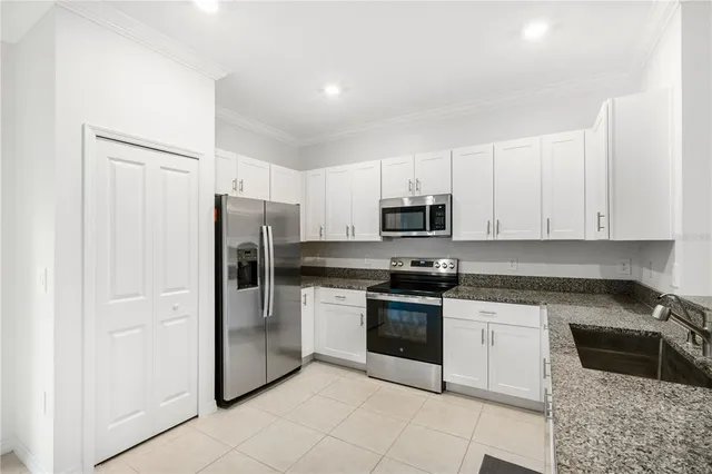 a kitchen with stainless steel appliances granite countertop a refrigerator sink and cabinets