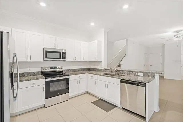 a kitchen with granite countertop white cabinets and white appliances