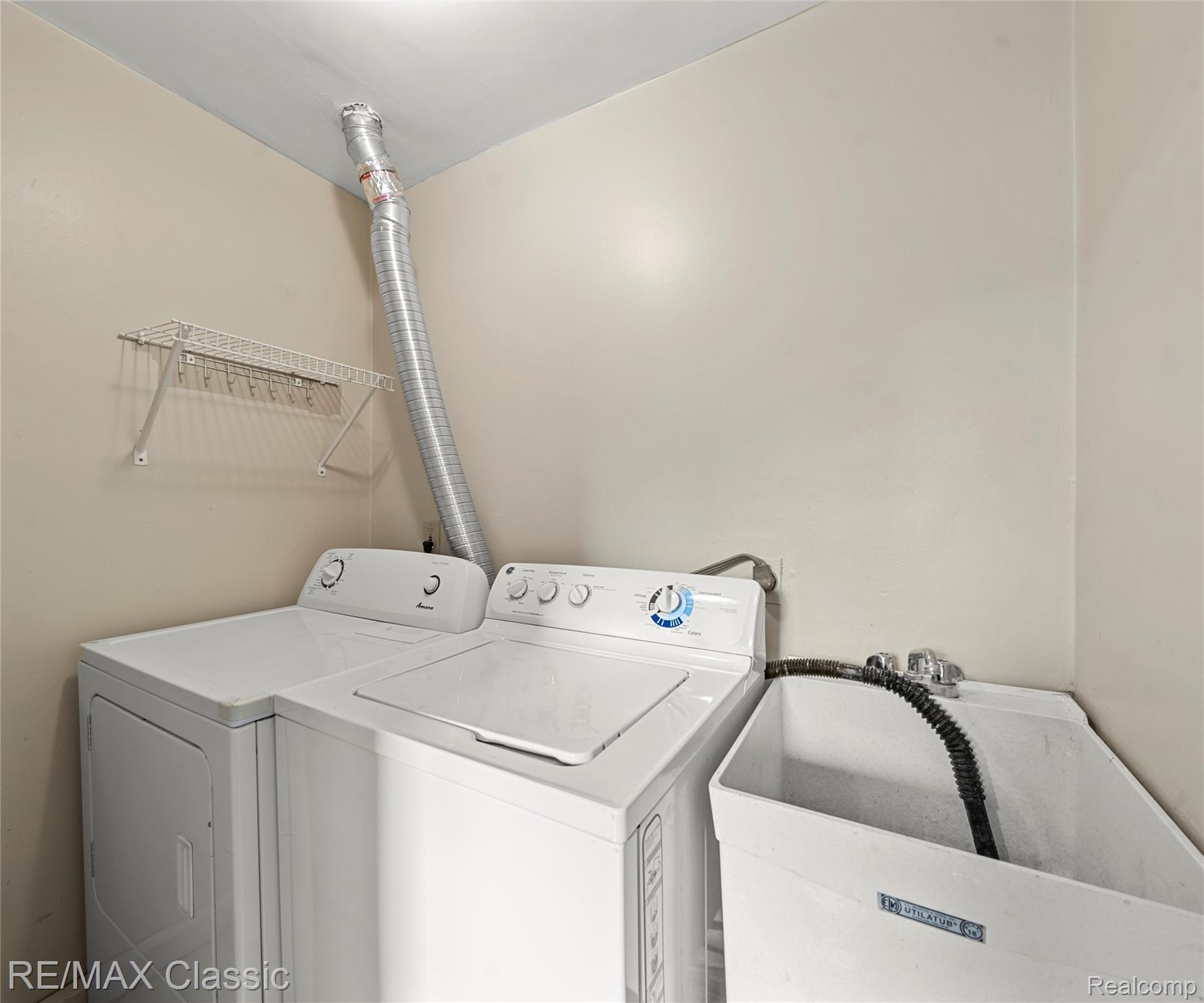 3941 Trumbull Detroit, MI 48208 - Photo 45 of 46 Dedicated laundry area featuring a utility sink, white appliances, and a wall-mounted drying rack